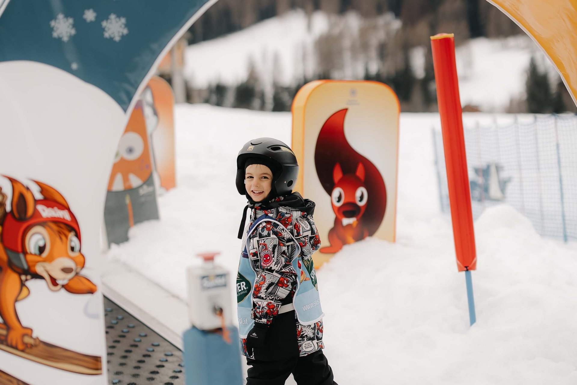 The in-house Rainer Ski School Child wearing ski helmet skiing at Family Resort Rainer in the snow