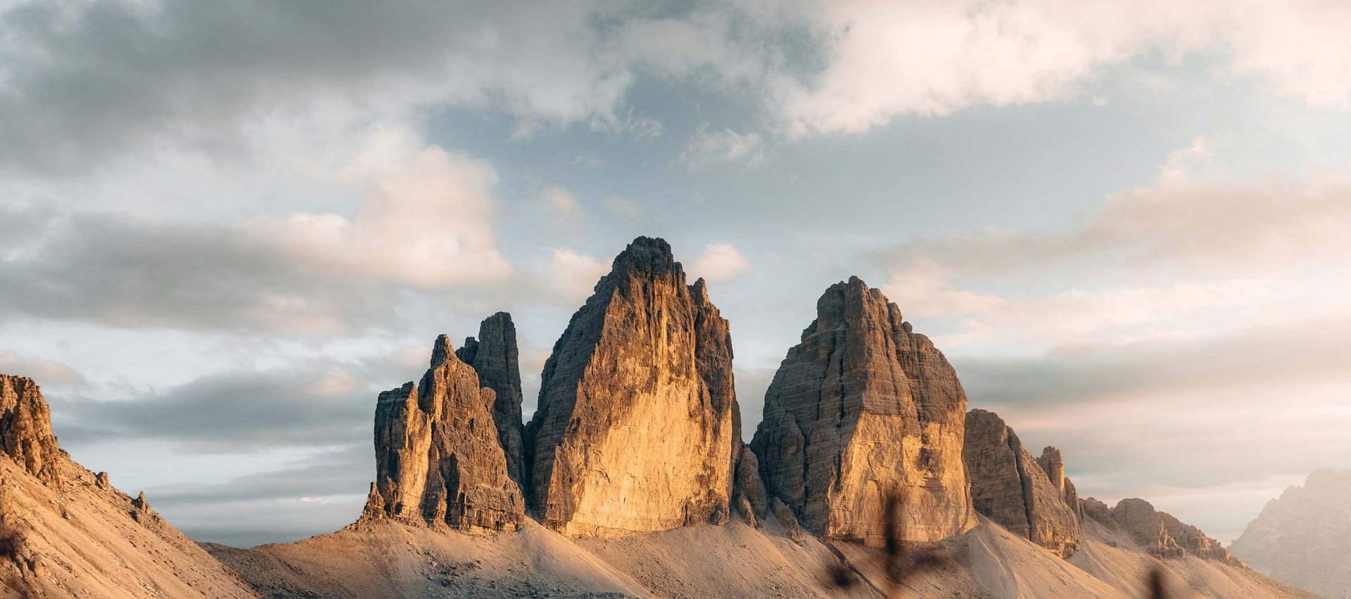 Sexten: a paradise for mountain lovers Sunlit rocky peaks of Dolomites with purple flowers in the foreground