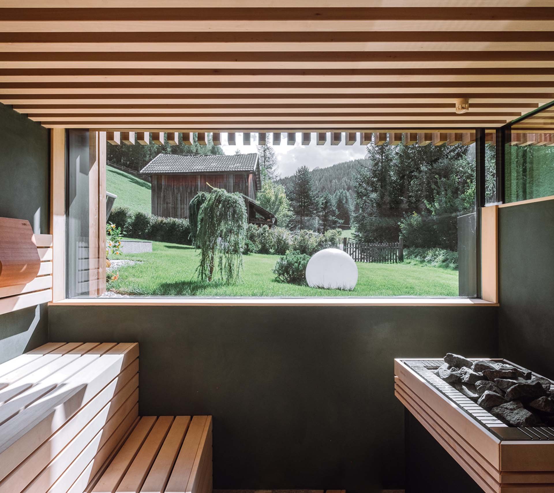 Scheda struttura - Residence Königswarte Strata Sauna moderna con panchina in legno e grande finestra sulla natura verde