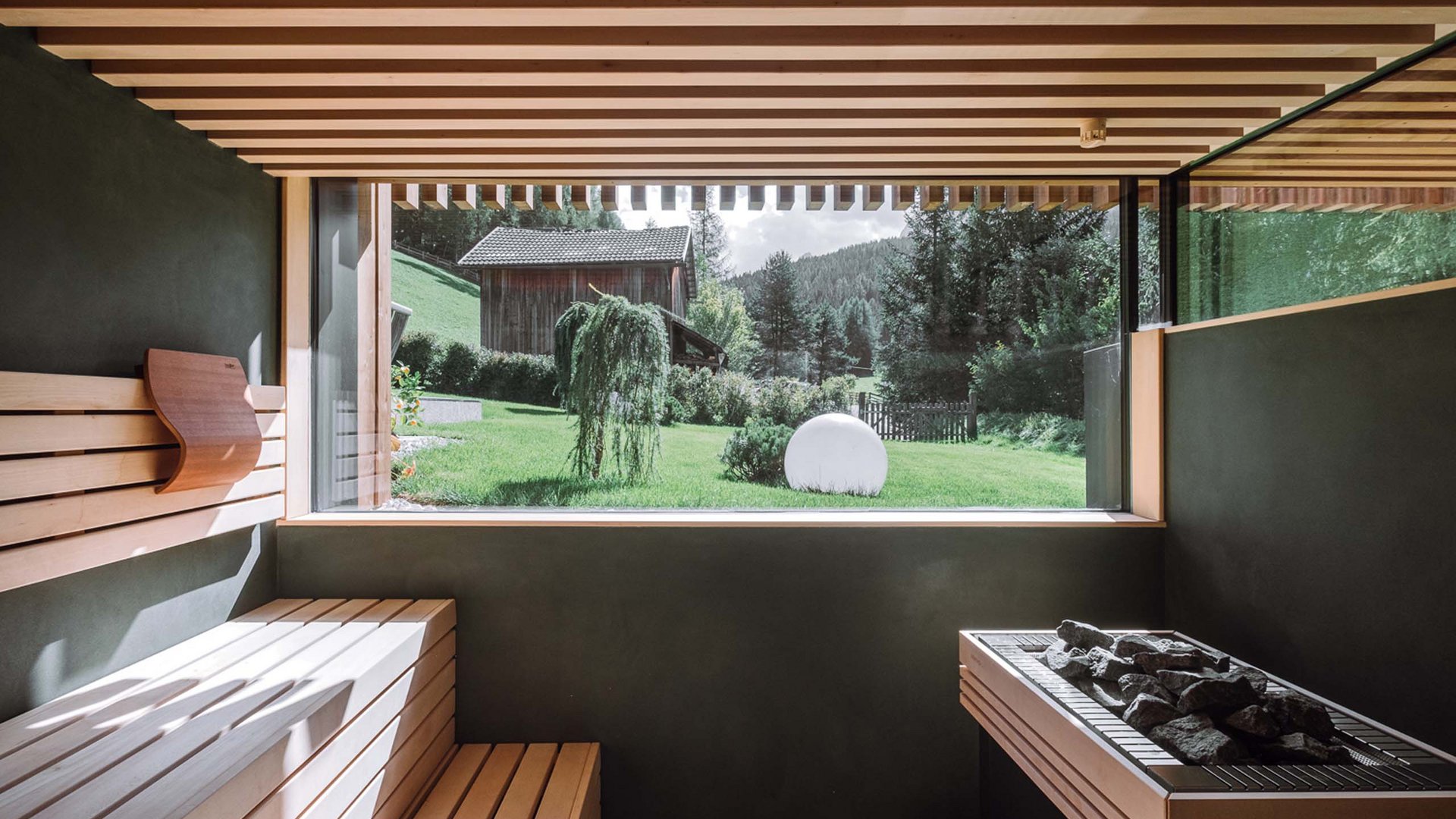 Residence Königswarte Strata Sauna moderna con panchina in legno e grande finestra sulla natura verde