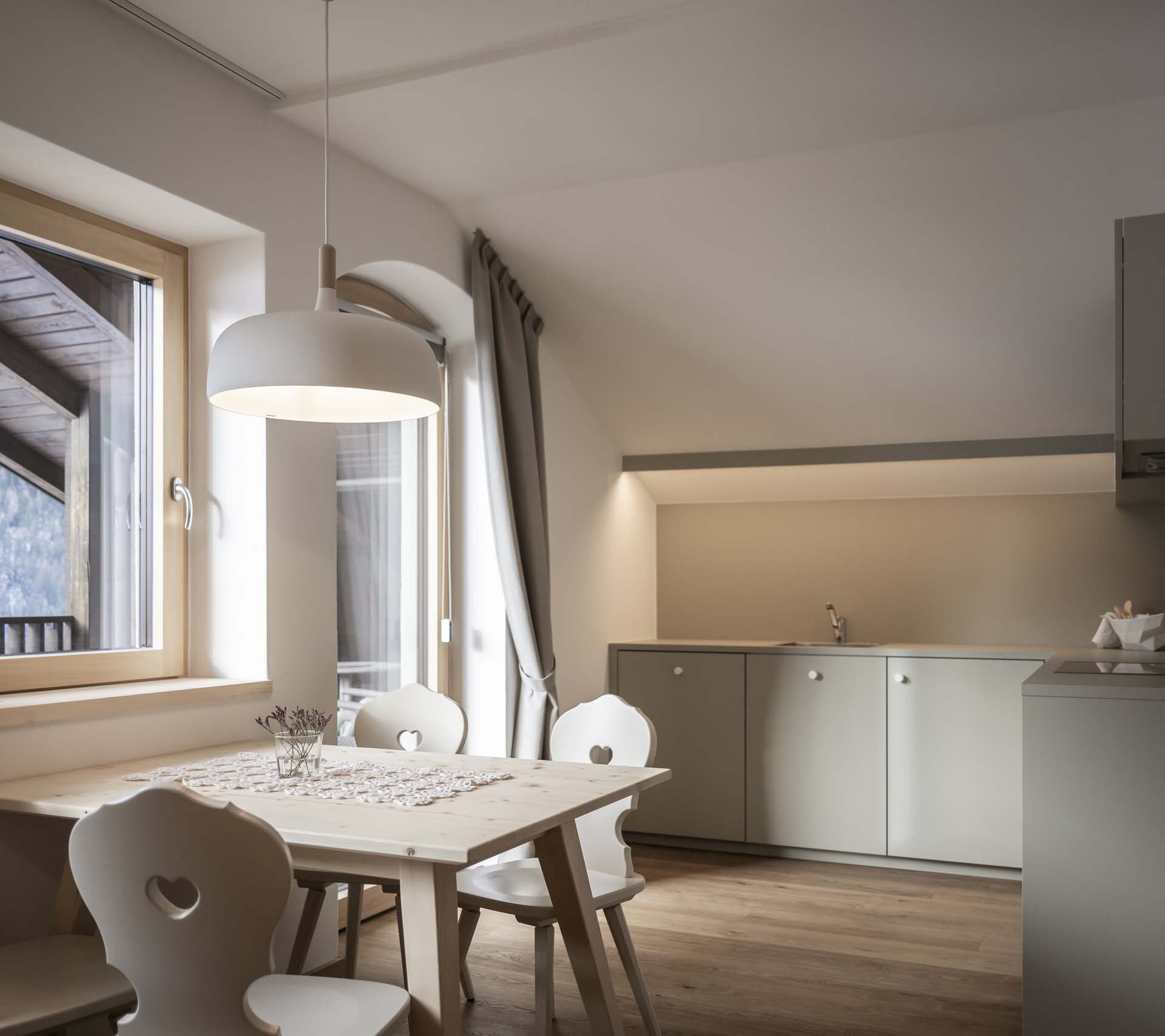 Betriebsdetailseite - Residence Villa Rainer Kleine moderne Küche mit Esstisch und Fenster mit Bergblick