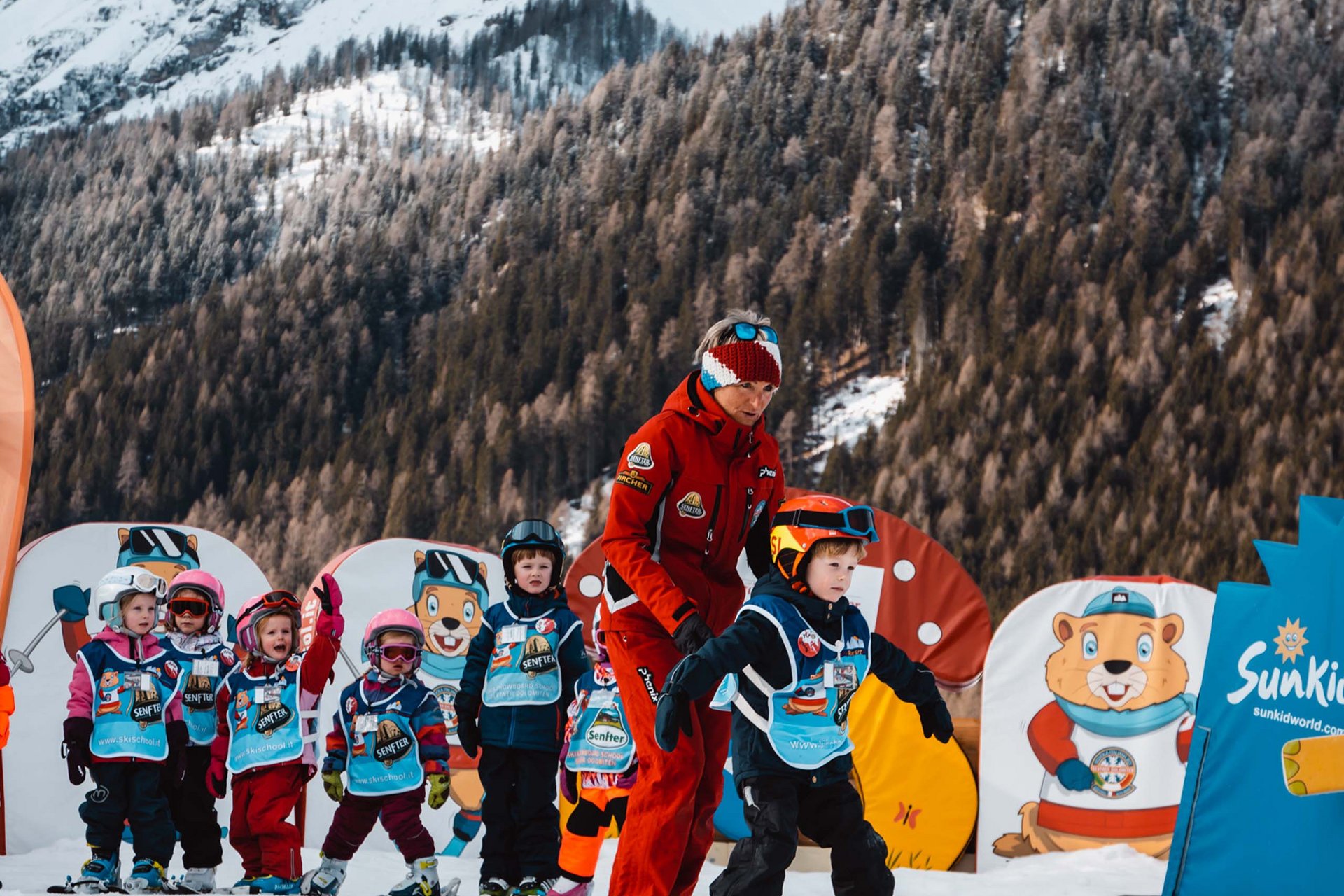 The in-house Rainer Ski School Child learning to ski with instructor on snowy mountain slopes