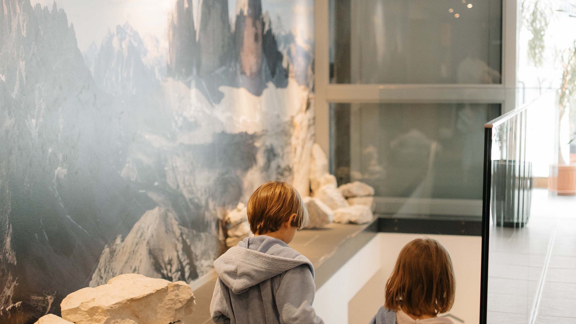 Family Resort Rainer Due bambini in accappatoi scendono le scale in un moderno ingresso d'hotel