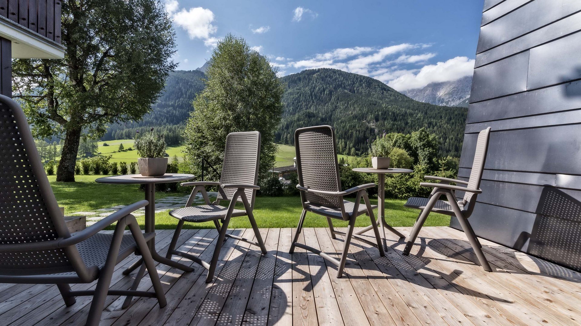 Naturerlebnis in der Villa Rainer Terrasse mit Stühlen und Tischen vor Berglandschaft bei Sonnenschein