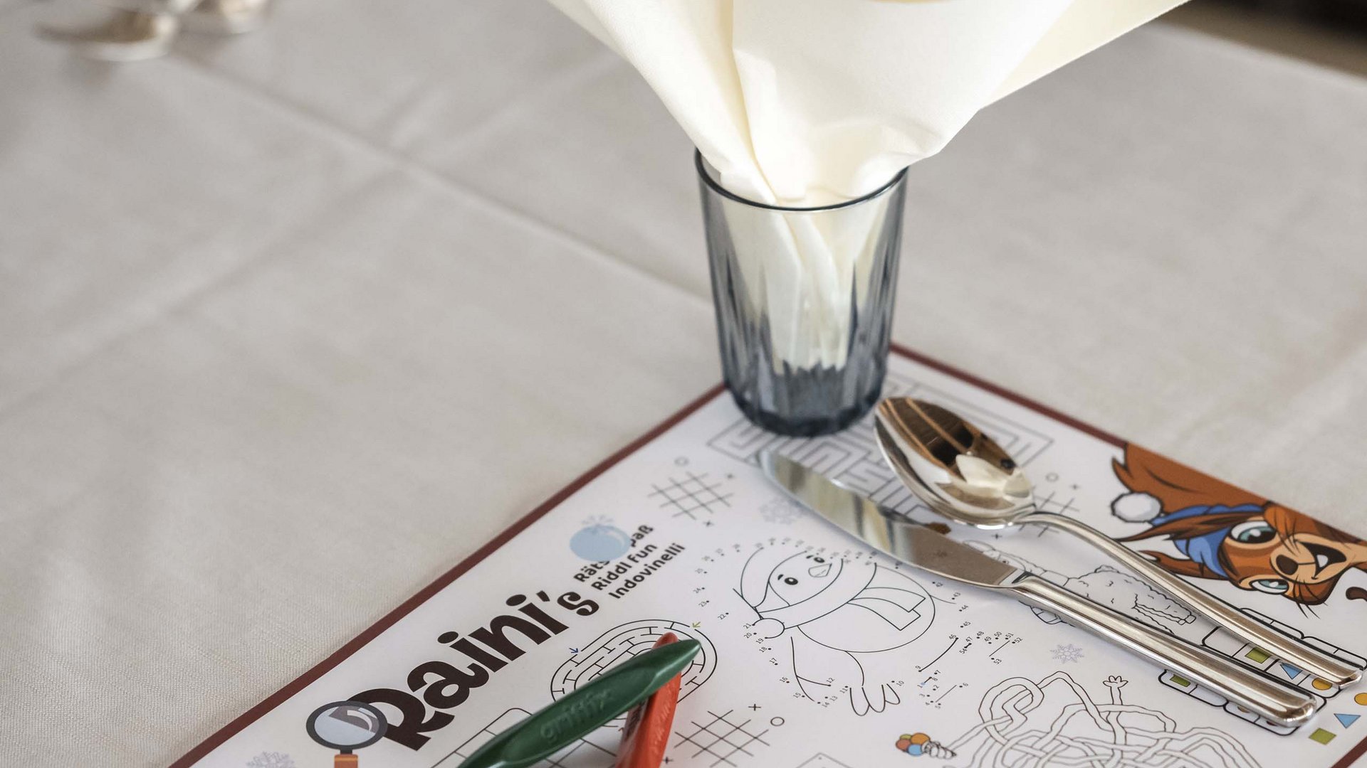 Family Resort Rainer Tavolo apparecchiato con giochi per bambini e posate in un ristorante