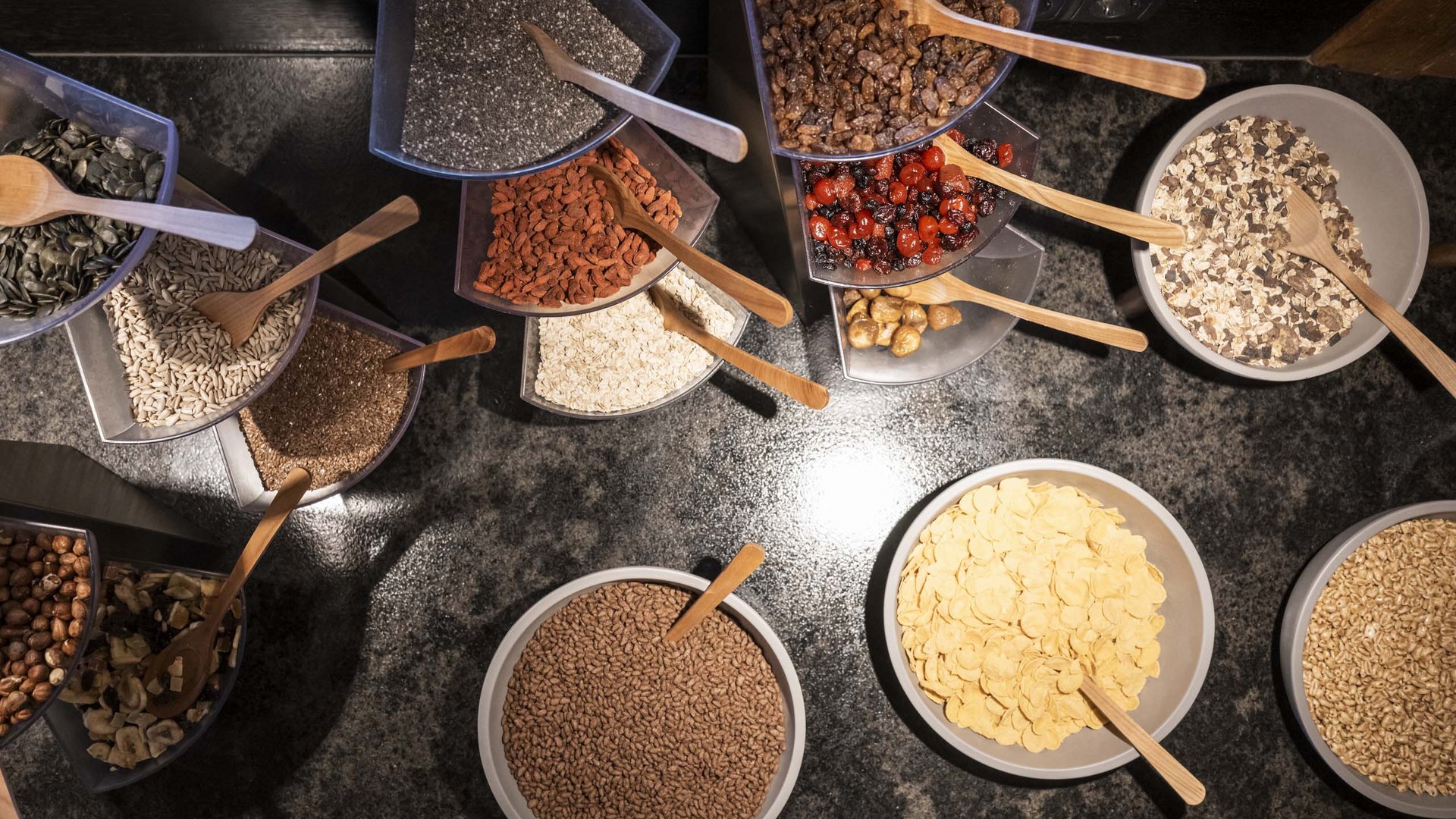 Family Resort Rainer Ciotole con cereali per la colazione, semi e frutta secca su piano scuro