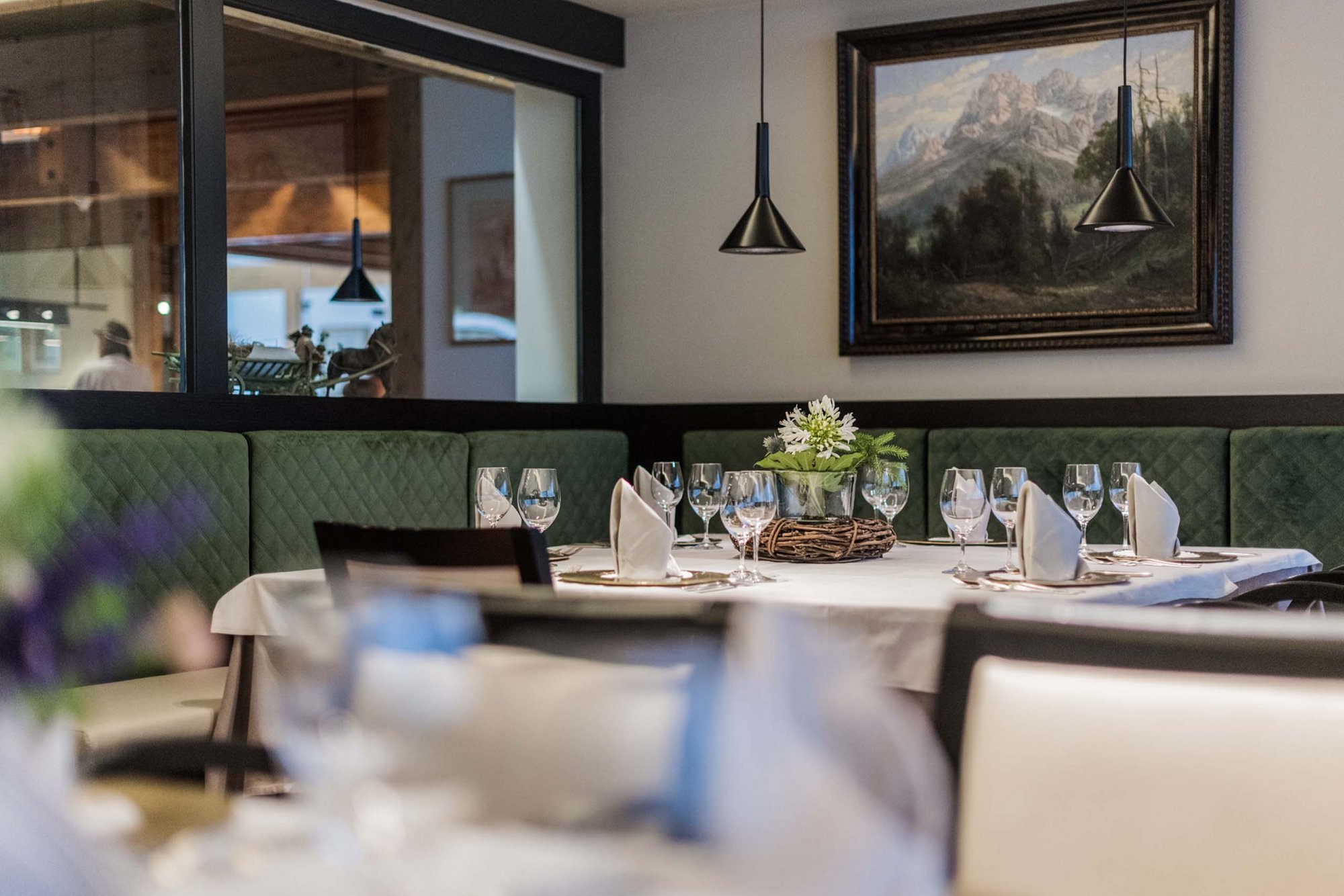 Gourmet delights from morning to night Elegant set table in restaurant with green upholstered sofa and mountain painting